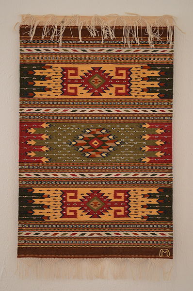 Woven rug of cotton and silk in tradicional design by Arnulfo Mendoza at the Museo de los Pintores Oaxaqueños in the city of Oaxaca. Attribution: AlejandroLinaresGarcia
