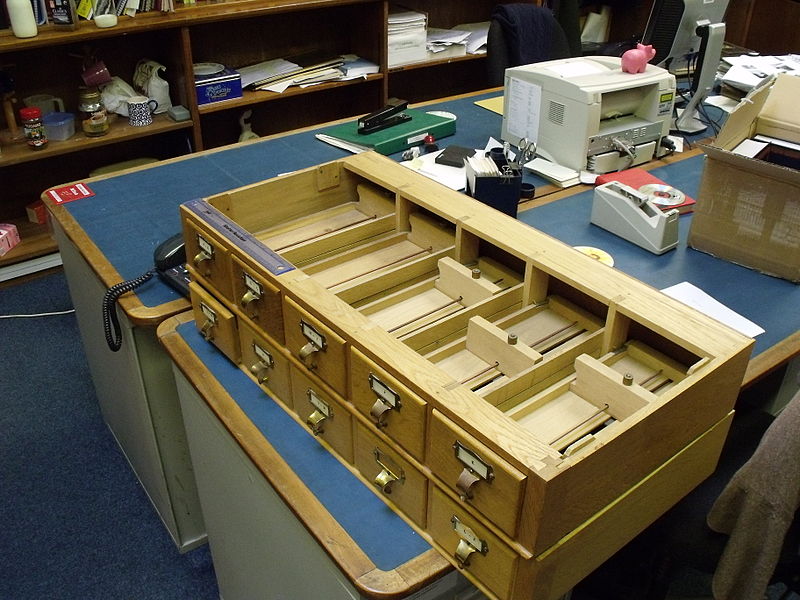 A look inside the drawers, showing the metal piece that holds the cards in place and the adjustable wood block in the back that keeps the cards tight. Photo: James Fishwick from Oxford, England via Wikimedia Commons